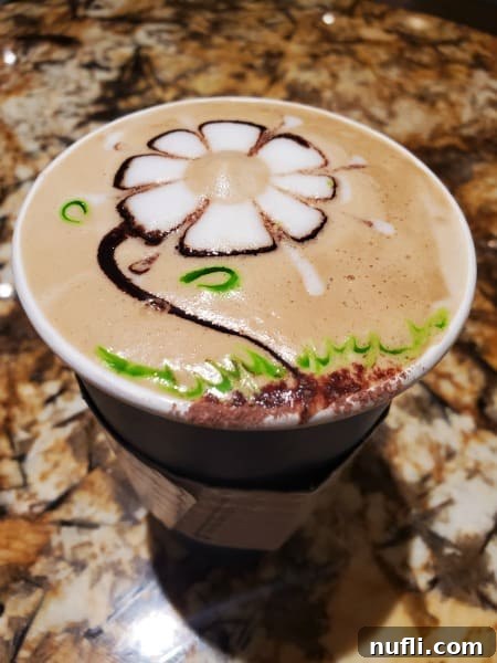espresso with a daisy flower design on top of it 
