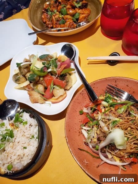 multiple plates with noodles, beef, chicken, and veggies