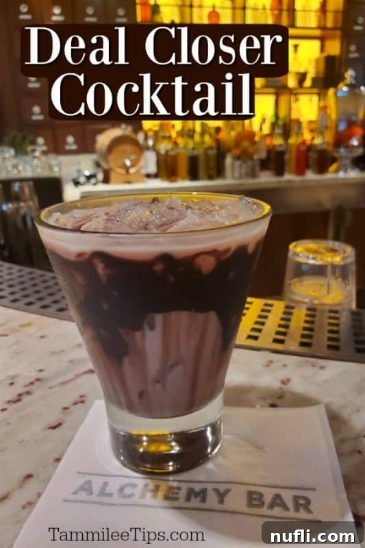 Deal Closer Cocktail served in a martini glass with a chocolate drizzle and a dark background on an Alchemy Bar napkin