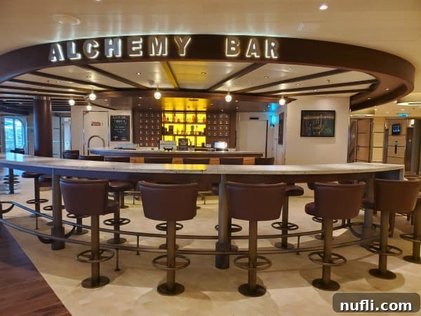 bar stools and counters with a bar behind it. Alchemy Bar sign over the bar