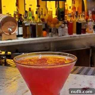 The Perfect Storm Cocktail: A vibrant pink drink in a martini glass, perfect for a tropical escape.
