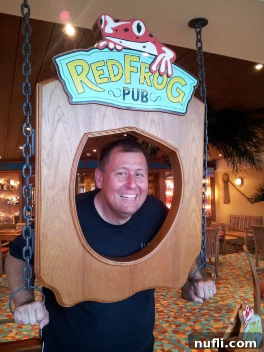 Everything You Need to Know About the Carnival Cheers Package 7 Red Frog Pub sign with john peeking through the middle of it.