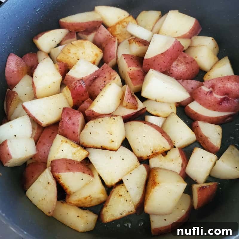 Red Breakfast Potatoes Recipe 5 Close-up of perfectly seasoned red breakfast potatoes in a dark skillet, ready to be enjoyed