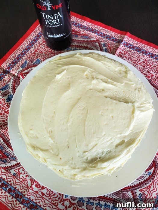 Port Wine Carrot Cake with Pineapple and Coconut 3 A beautifully presented carrot cake on a pristine white plate, accompanied by a bottle of Ficklin's Old Vine Tinta Port, showcasing the inspiration behind the recipe.