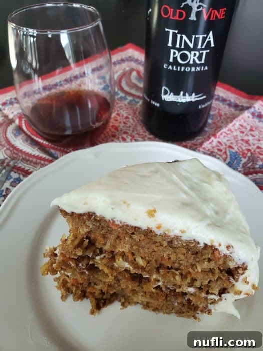 Port Wine Carrot Cake with Pineapple and Coconut 4 A perfect slice of carrot cake, generously frosted, stands on a white plate, flanked by a bottle of Old Vine Tinta Port and a glass of the exquisite wine, inviting indulgence.