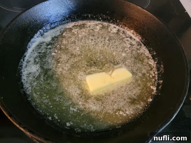 Easy German Apple Pancakes 4 Butter melting in a cast iron skillet for a German Apple Pancake