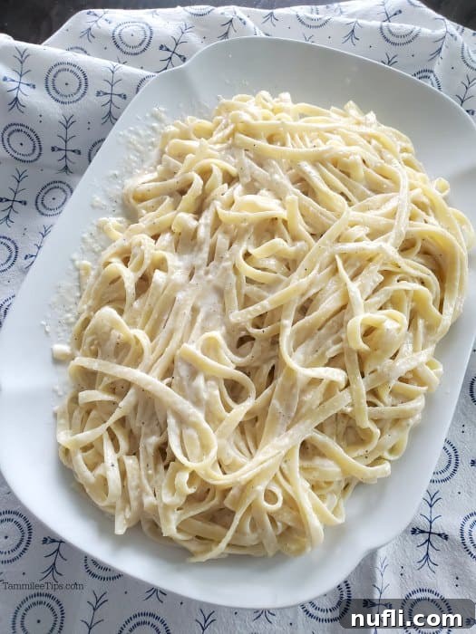 Olive Garden fettuccine alfredo on a white platter with a cloth napkin