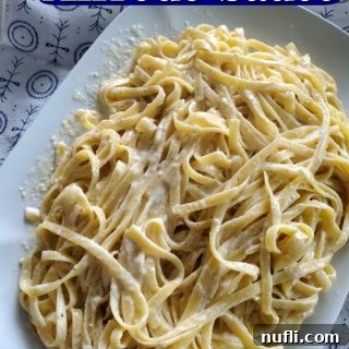 Olive Garden Alfredo Sauce text over a large platter of fettuccine alfredo