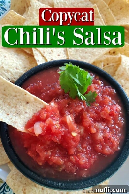 Chilis Restaurant Style Salsa Recipe 2 Copycat Chili's Salsa in a black bowl with a tortilla chip in it.
