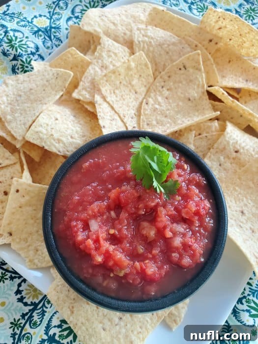 Chilis Restaurant Style Salsa Recipe 3 Chili's salsa copycat recipe in a black bowl surrounded by tortilla chips
