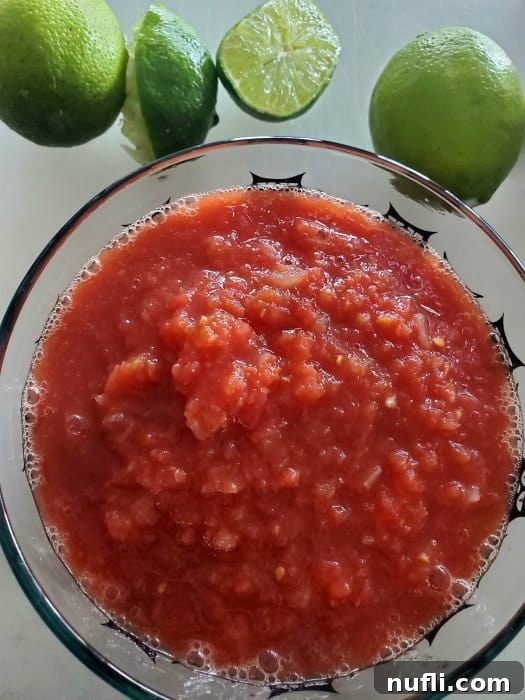 Chilis Restaurant Style Salsa Recipe 4 Chili's salsa in a glass bowl with limes next to it.