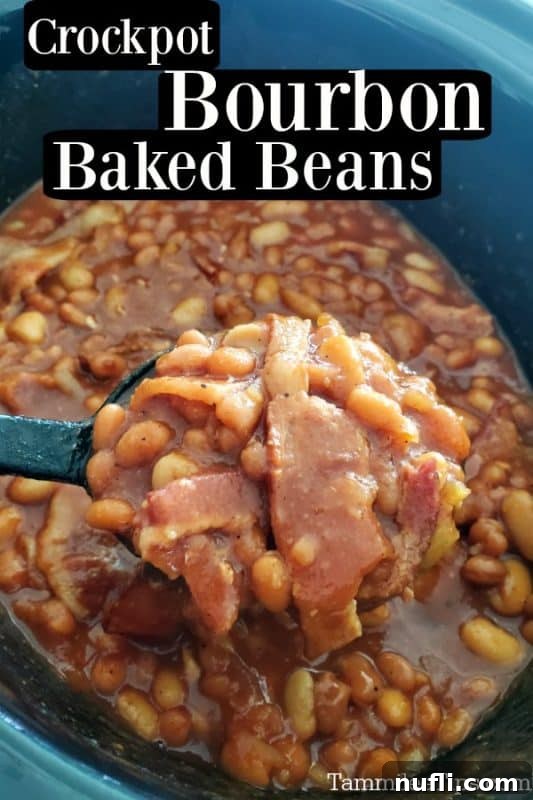 Crockpot bourbon baked beans over a large spoon scooping beans and bacon from the slow cooker 