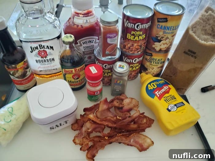 Worcestershire Sauce, bourbon, ketchup, molasses, baked beans, spices, mustard, salt, and bacon on a white counter