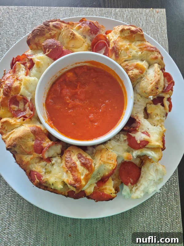 Closeup of Pepperoni Pizza Monkey Bread on a white circle plate, showcasing the cheesy, golden pieces
