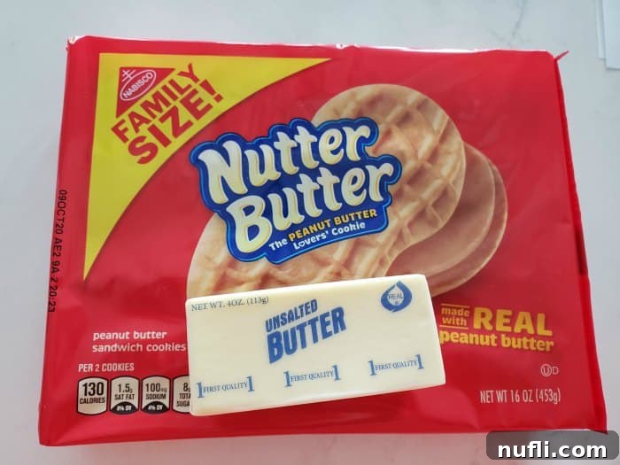 A family-size package of Nutter Butter cookies and a stick of butter on a clean white kitchen counter, ready for crust preparation.