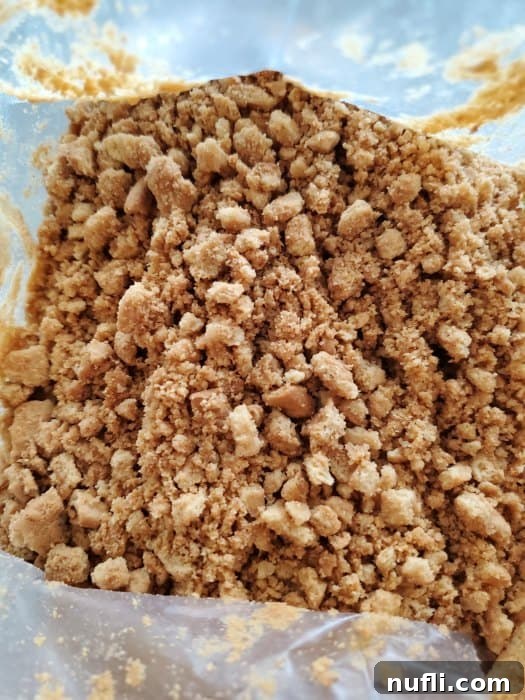 Crushed Nutter Butter cookies in a plastic bag, showing a fine, even texture, ready for the next step.