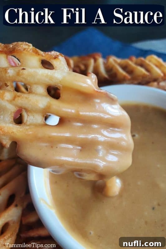 Chick-fil-A Sauce over a waffle fry dipping into a white bowl with Chick-fil-A Sauce