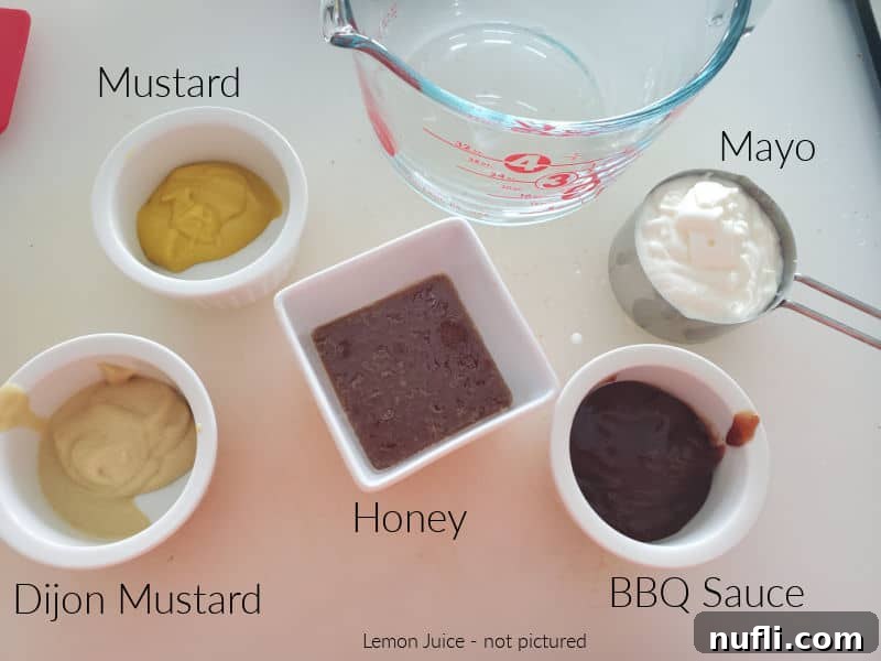 Mustard, mayo, bbq sauce, honey, and dijon mustard in bowls on a counter.