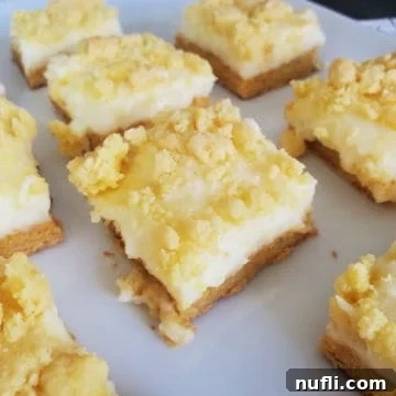 Lemon Cheesecake Bars Video Recipe 8 Squares of Lemon Cheesecake Bars on a white platter