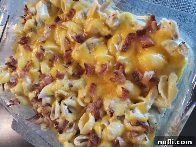 Chicken Bacon Ranch Casserole topped with shredded cheese in a baking dish