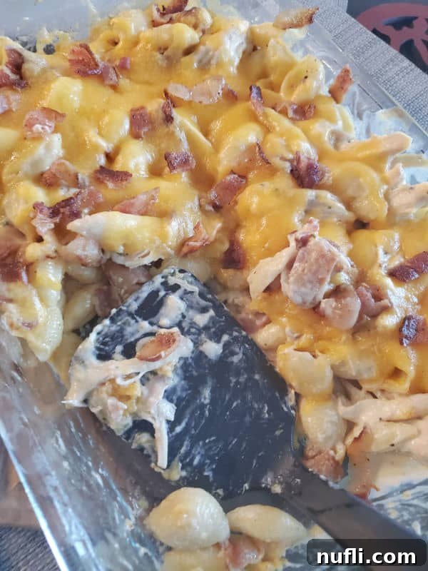 Chicken Bacon Ranch Casserole topped with shredded cheese in a baking dish