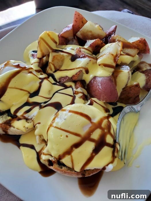 Caprese Eggs Benedict and red breakfast potatoes covered in hollandaise sauce
