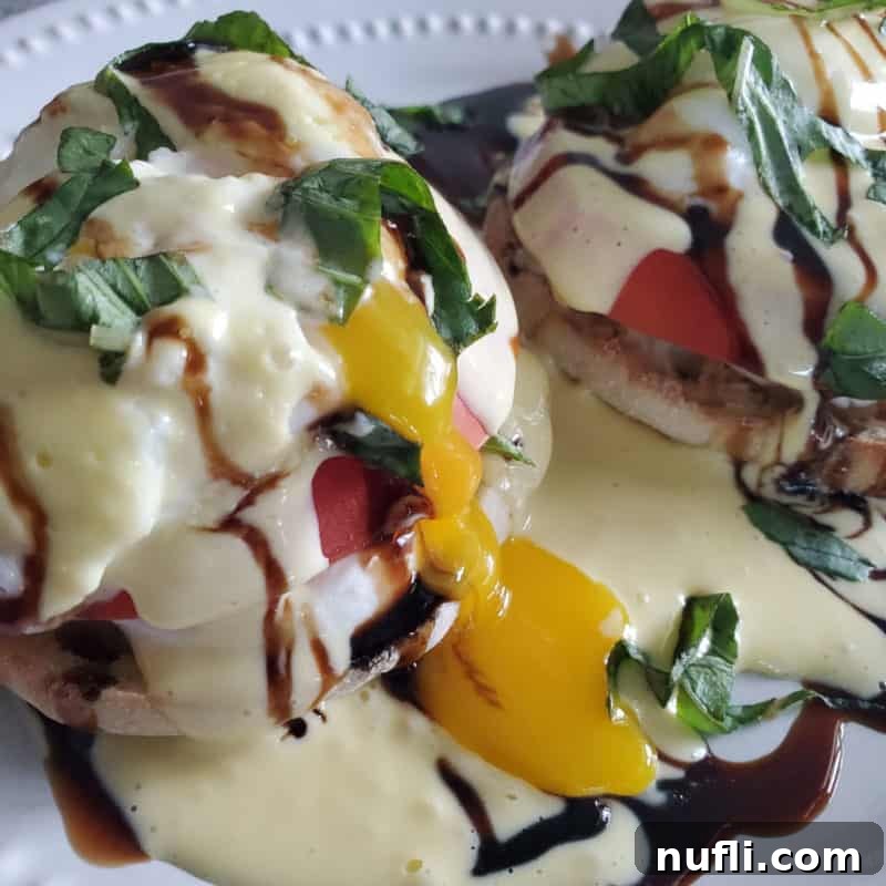 Caprese Eggs Benedict with egg yolk running down the side