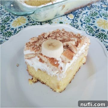 Ultimate Banana Pudding Poke Cake 5 A delicious slice of Banana Pudding Poke Cake on a white plate next to the full cake dish.