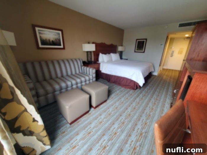 Hotel room wtih a couch, bed, and workspace