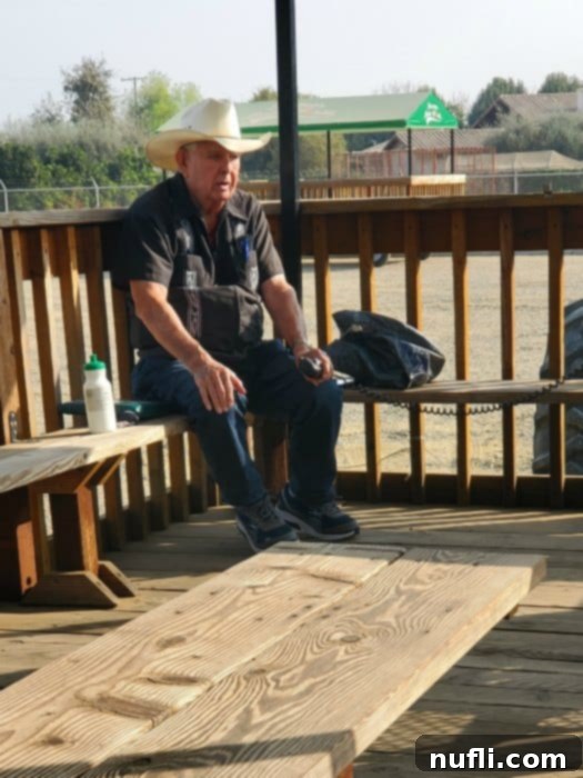 Farmer bob sitting on a wooden bench holding a microphone
