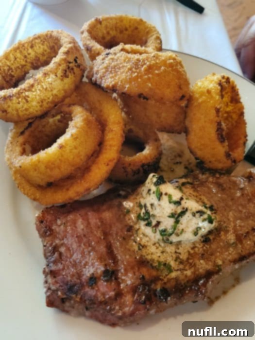 steak and onions rings on a white plate