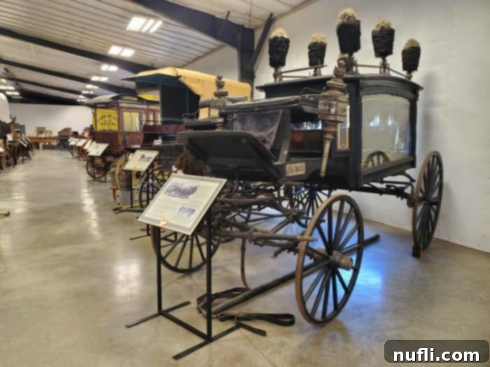 museum with historic carriages and signs  in front of them. 