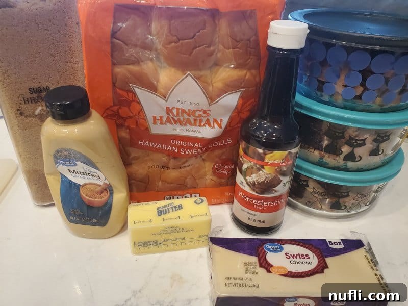 Ingredients for Ham and Cheese Sliders, including Hawaiian sweet rolls, ham, Swiss cheese, butter, brown sugar, Dijon mustard, and Worcestershire sauce