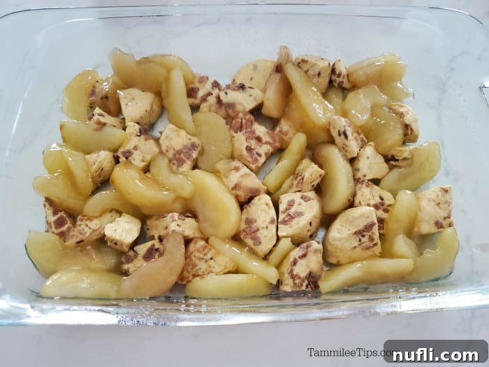 Cinnamon Roll Apple Pie Bake 4 Cinnamon roll pieces and apples in a glass baking dish