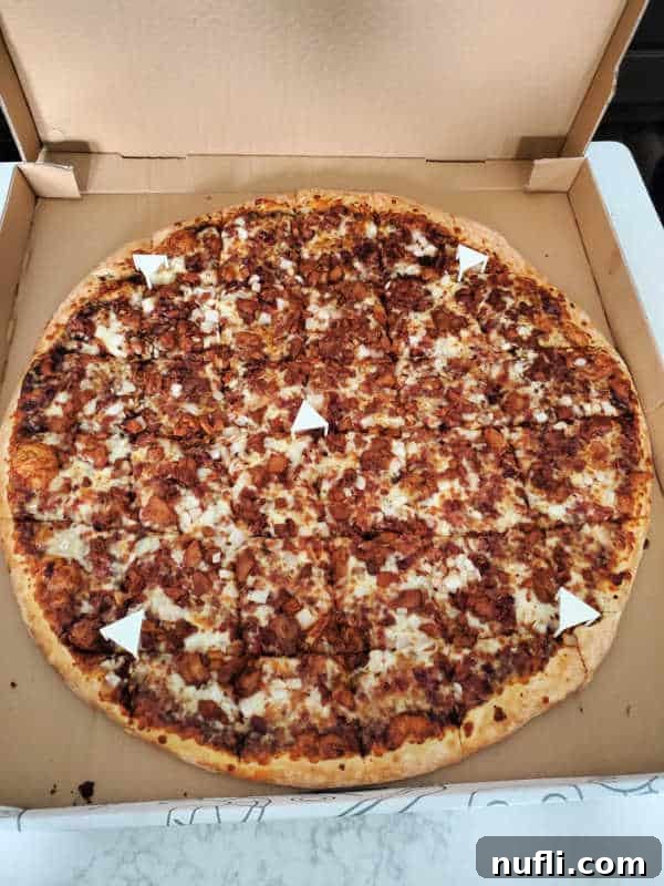 Spokane's Top Pizza Spots 15 Pizza covered in meat in a cardboard delivery box