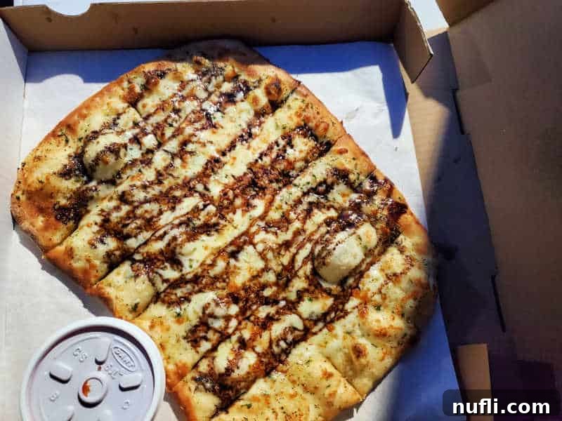 Spokane's Top Pizza Spots 27 Cheese bread covered in a balsamic drizzle in a cardboard delivery box