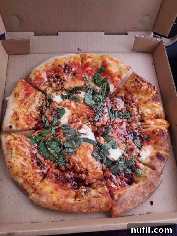 Spokane's Top Pizza Spots 10 pizza with basil and cheese in a cardboard pizza delivery box
