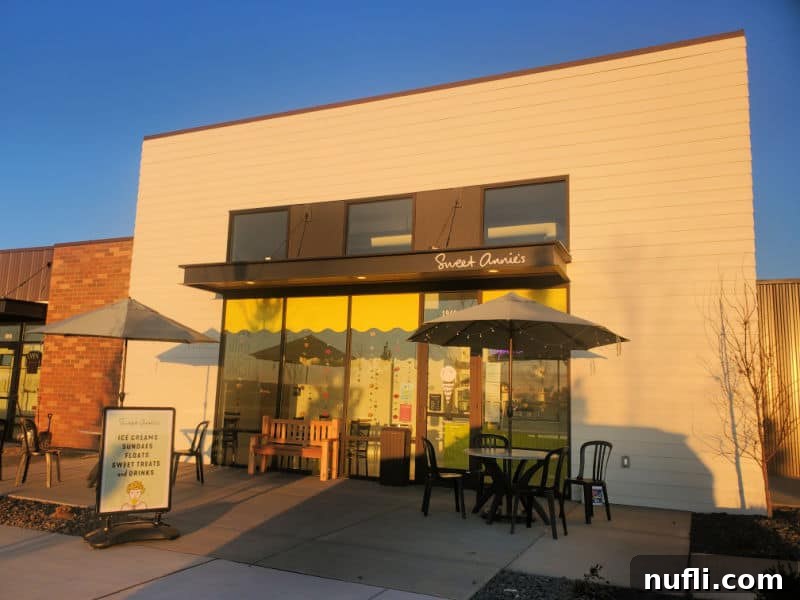 Sweet Annies sign over the entrance to the ice cream shop with tables and chairs outside