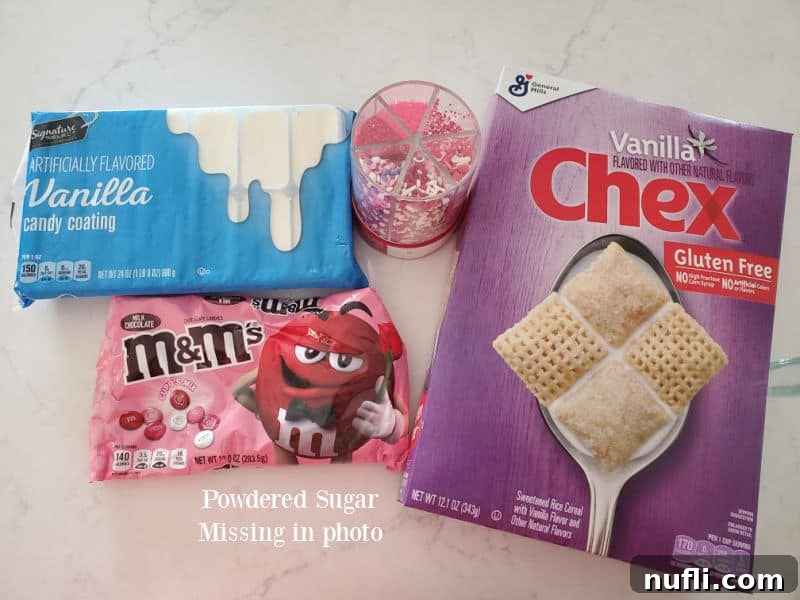 Ingredients for Valentine's Day Muddy Buddies laid out on a marble counter: vanilla Chex cereal, red and pink M&Ms, white candy coating, and festive sprinkles.