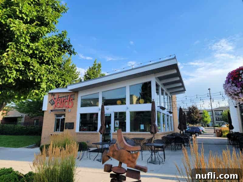 The Yards Bruncheon sign on a building with outdoor seating and a metal sculpture
