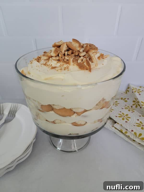 Delicious Magnolia Bakery Banana Pudding in a glass trifle dish with crushed Nilla wafers sprinkled on top.