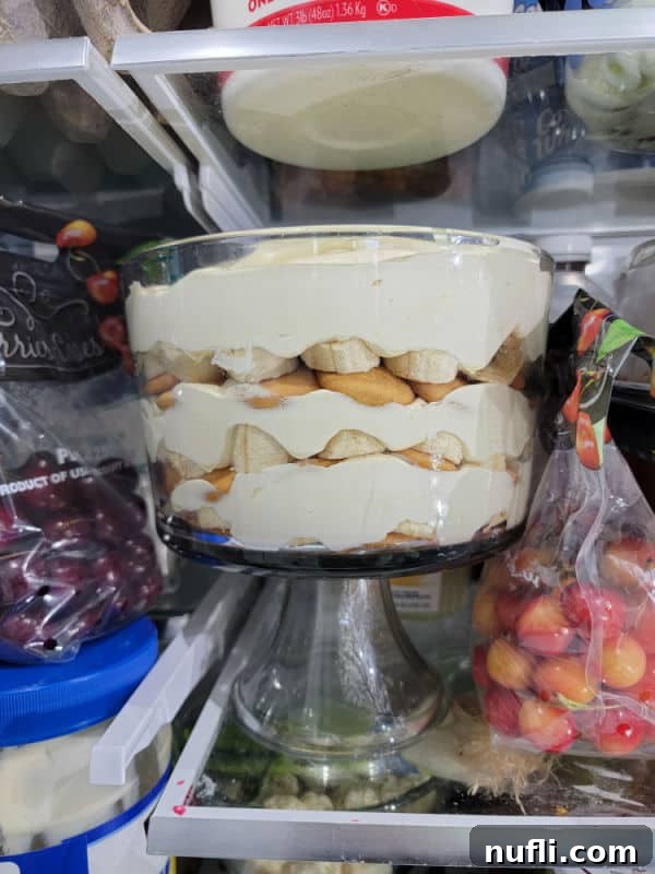 Magnolia Bakery Banana Pudding in a glass trifle dish, covered and chilling in the refrigerator.