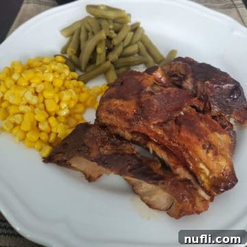 Dr. Pepper ribs next to corn and green beans on a white plate