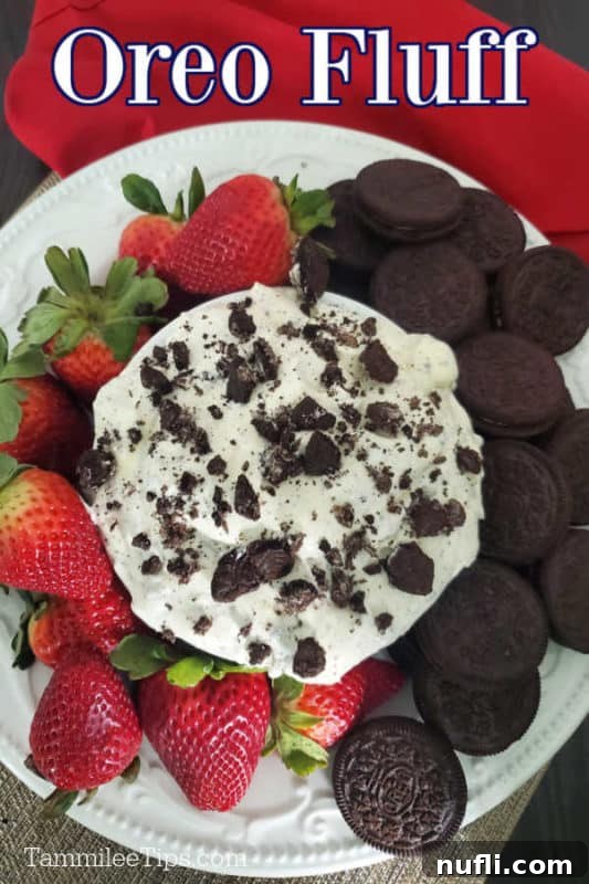 Oreo Fluff text over a bowl of Oreo Cookie Salad on a white plate with strawberries and Oreo Cookies