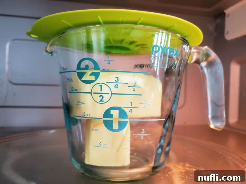 butter in a measuring cup with a plastic cover over it
