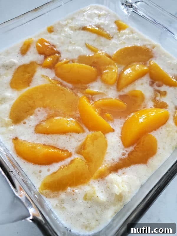 peaches in batter in a glass baking dish. 