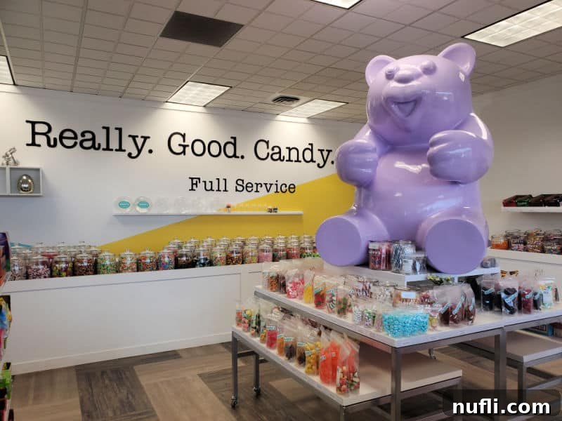 purle gummy bear statue on the top of candy displays and really good candy on the back wall