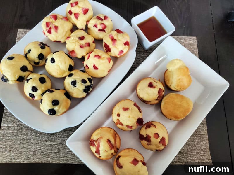 Two white platters filled with freshly baked pancake muffins, some drizzled with maple syrup, next to a bowl of golden syrup, ready for a delightful breakfast.