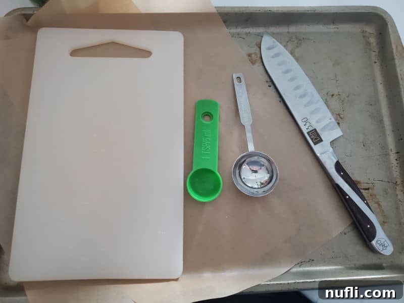 baking sheet with a cutting board, measuring spoons, and sharp knife