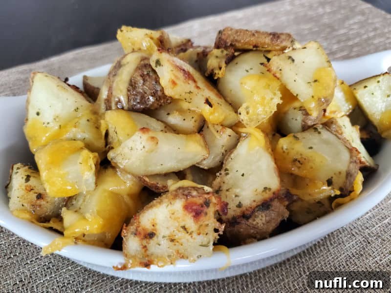 cheesy covered hidden valley ranch potatoes in a white baking dish on a placemat